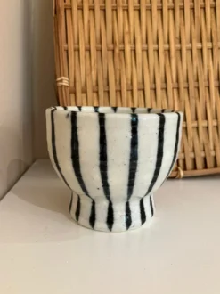 Hvid keramikkop på fod med mørkeblå striber