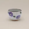 Kop med lilla blomster og brun kant