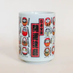 Kop med små daruma-figurer med forskellige udformninger